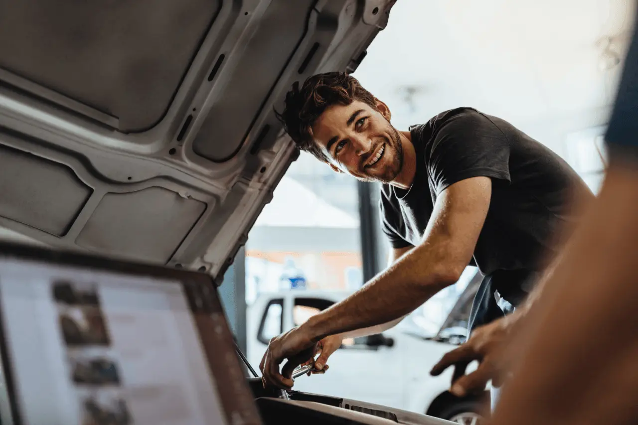 Ein Mann bei der Reparatur eines Autos in einer Werkstatt