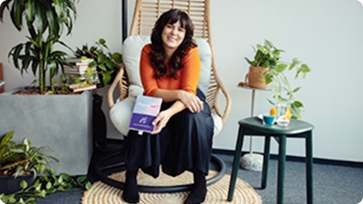 Eine Frau zu Hause in Ihrem Sessel mit einer Broschüre in der Hand