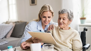 Eine Dame die einer älteren Dame einen Zettel zeigt